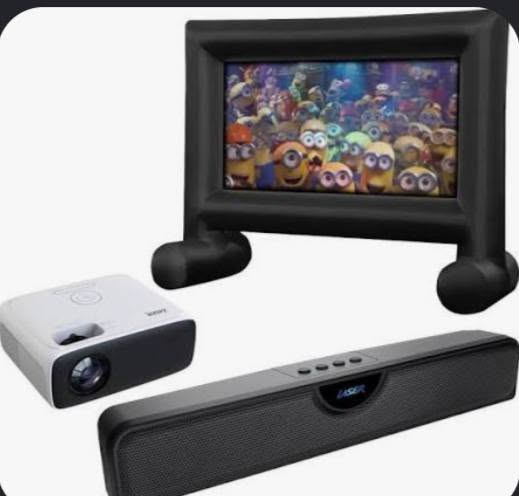 Inflatable movie screen with projector and speakers set up for a backyard movie night